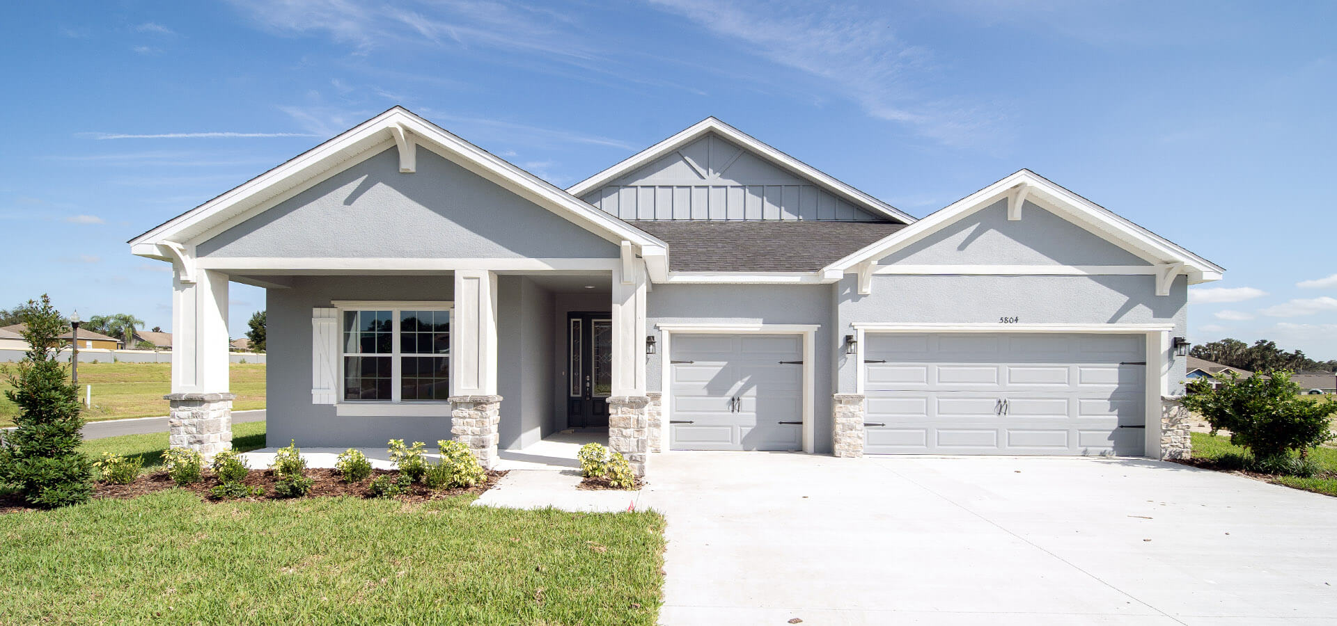 Florida new home exterior with 3-car garage and large columned front porch